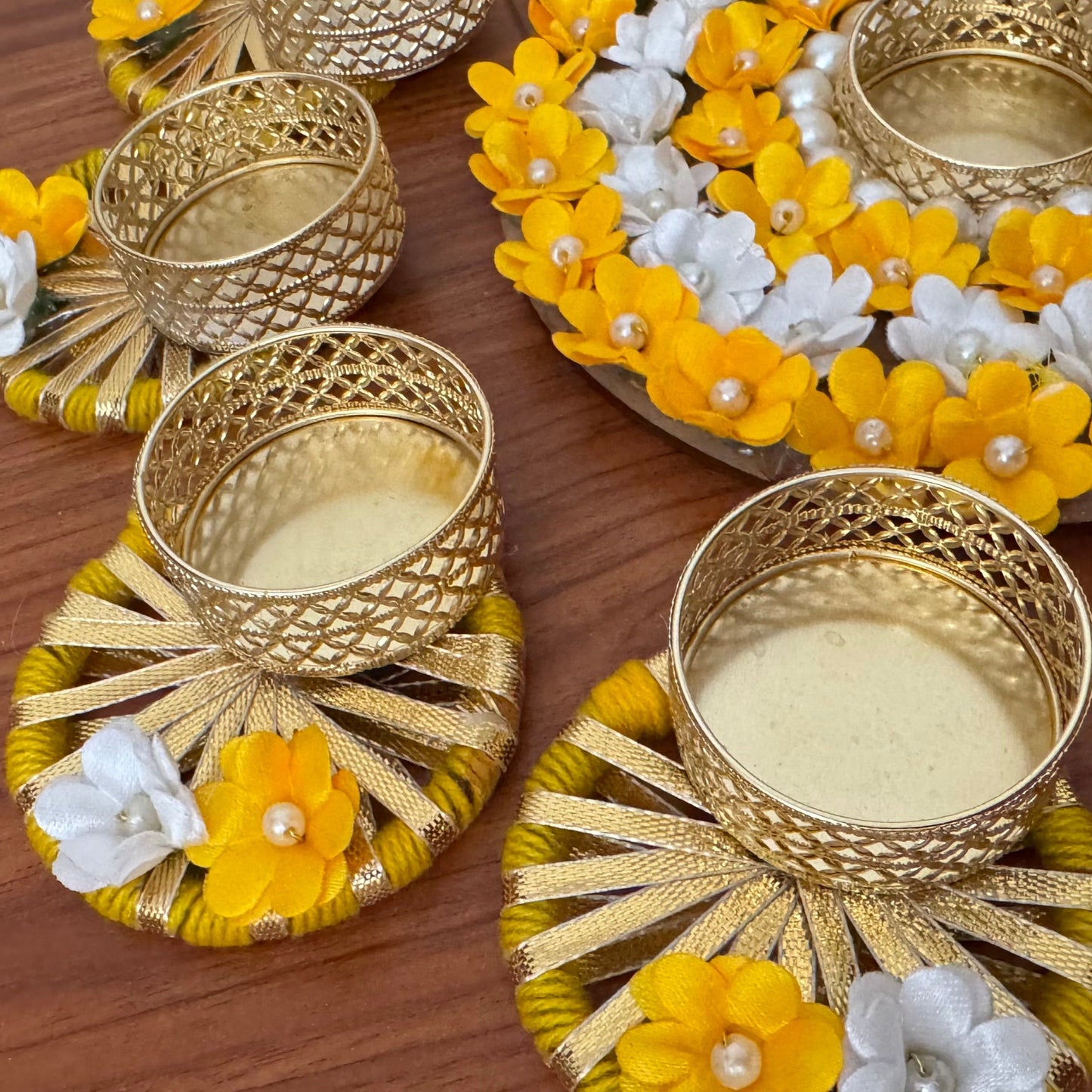 Decorative gold tea light holders with yellow and white flowers