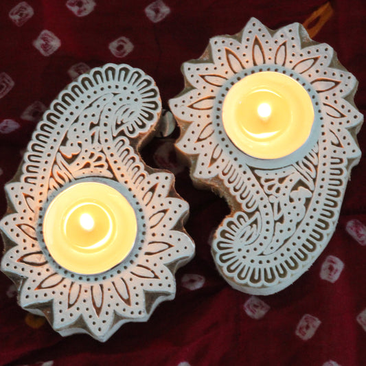 Decorative candle holders with intricate designs on a red bandani background