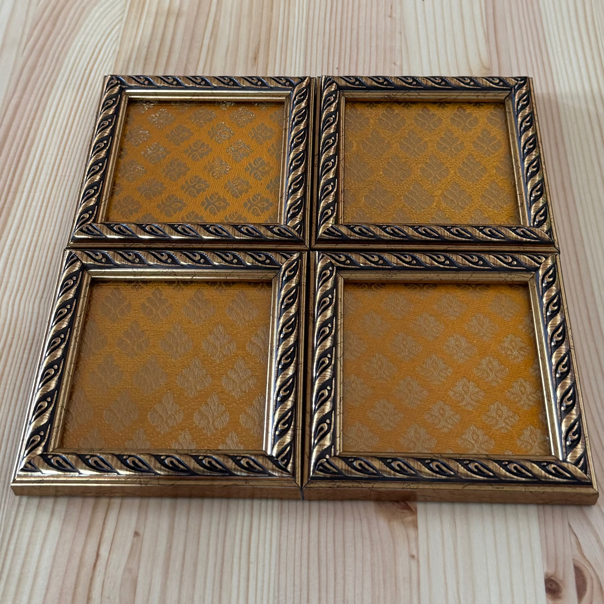 Decorative yellow with gold pattern wooden coasrer on a wooden surface