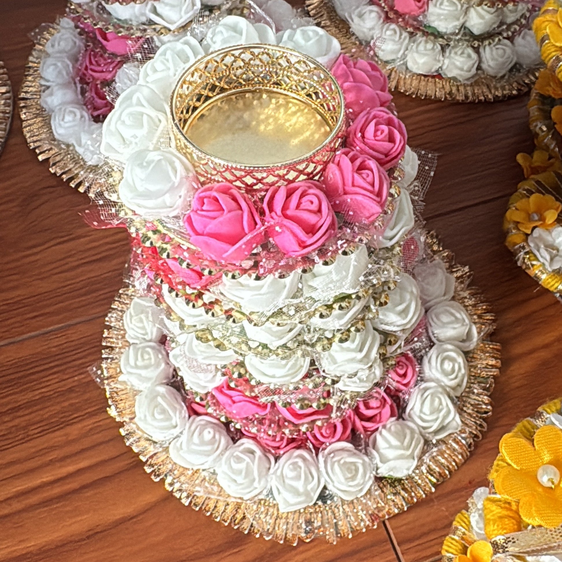 Decorative items with pink, white, and gold colours on a wooden surface