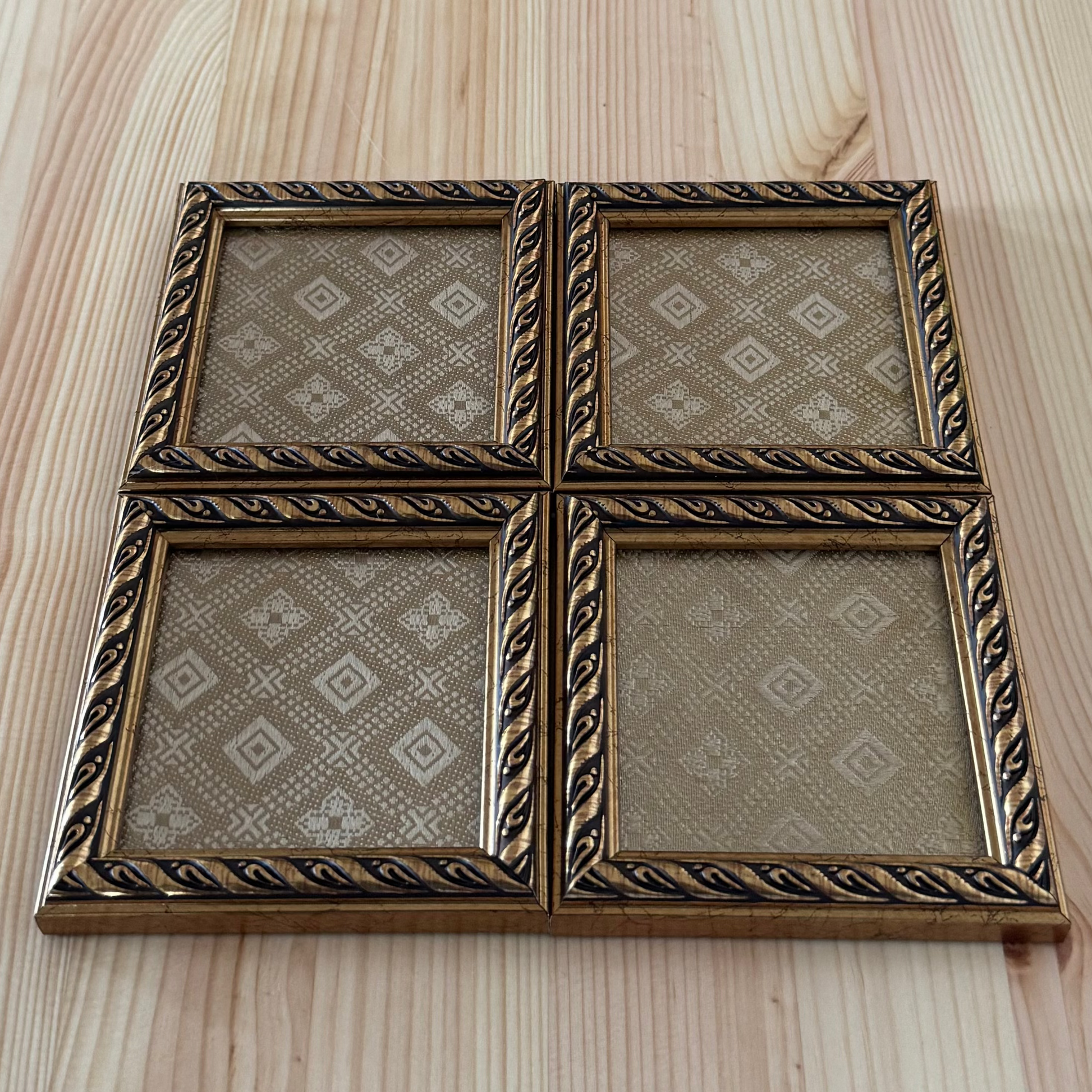 Decorative gold brocade fabric coaster with intricate patterns on a wooden surface.