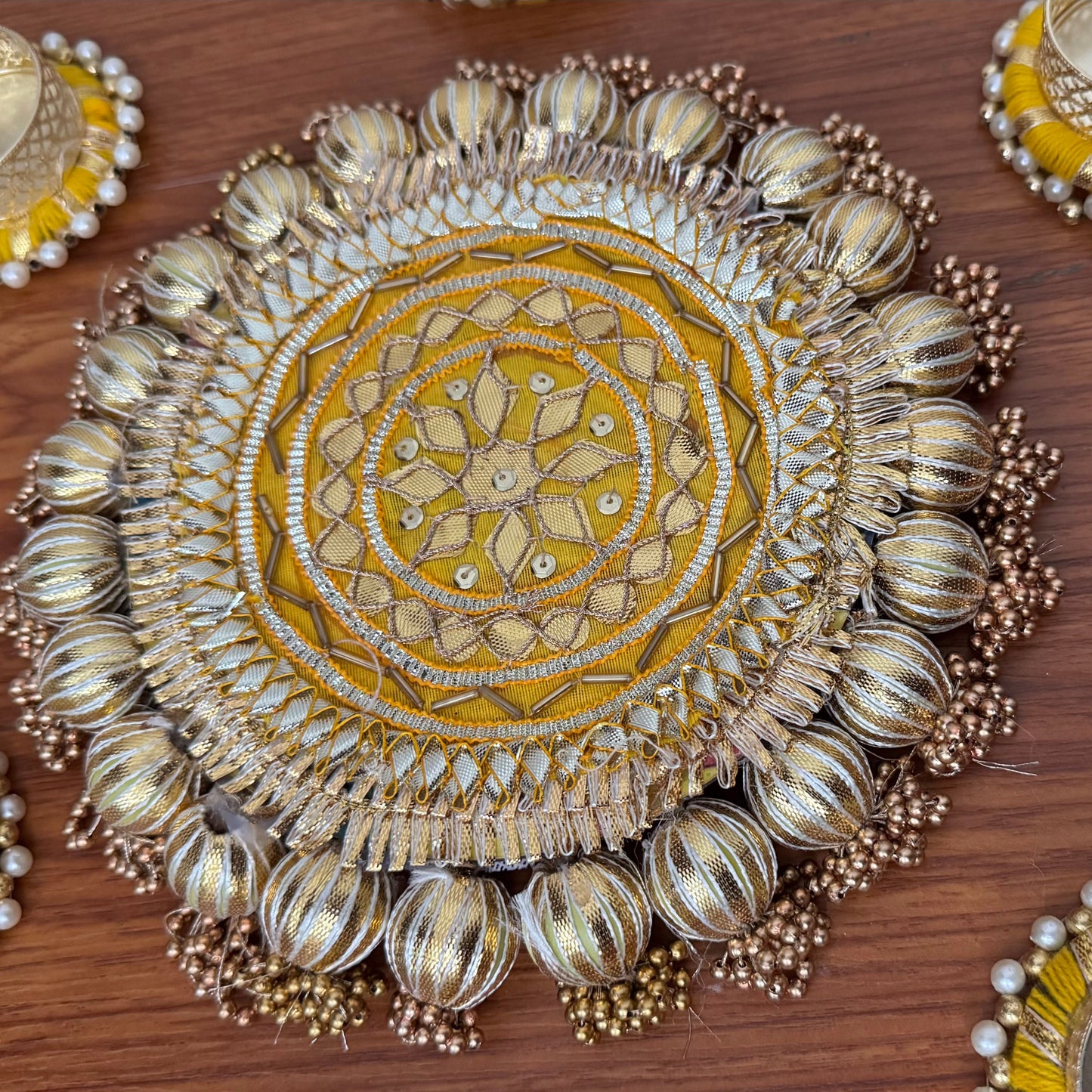 Decorative yellow and gold circular piece with gota patti work