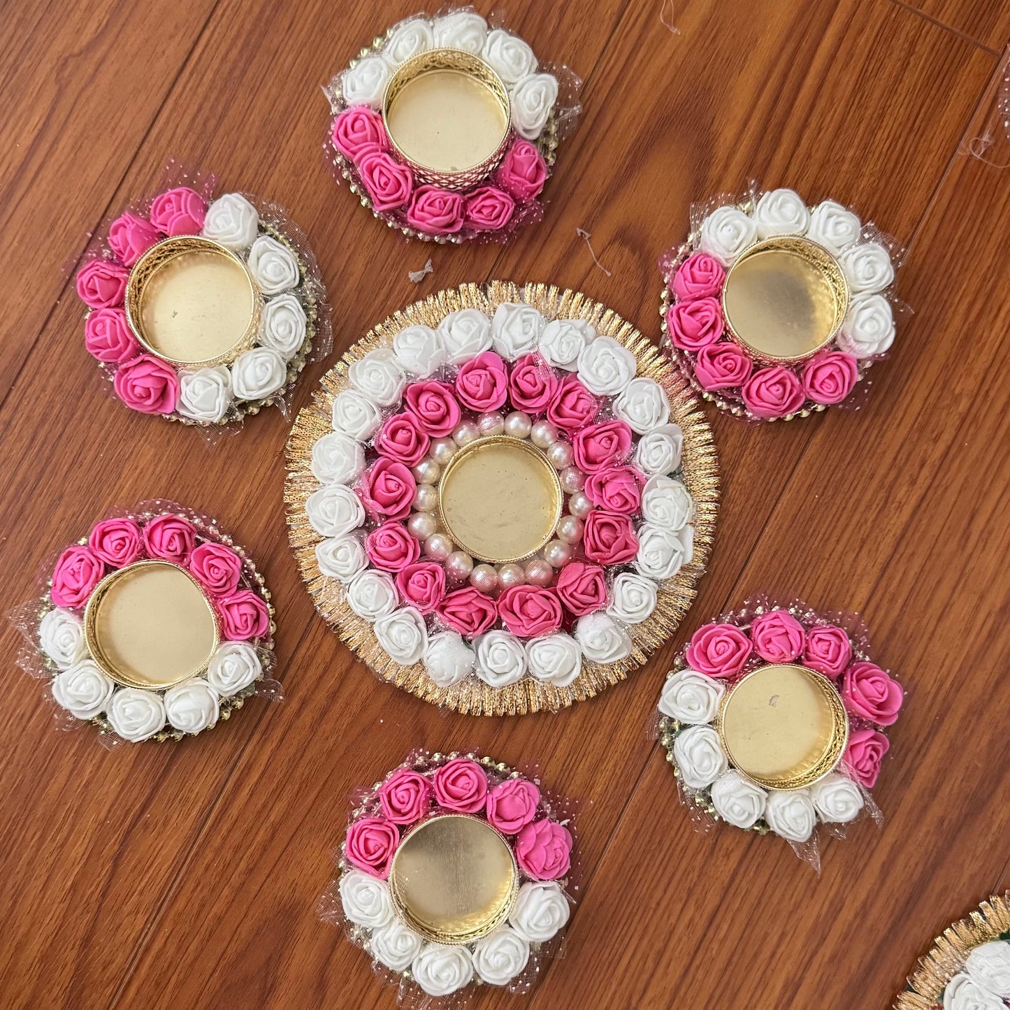 Decorative flower arrangements with tea light candles on a wooden floor