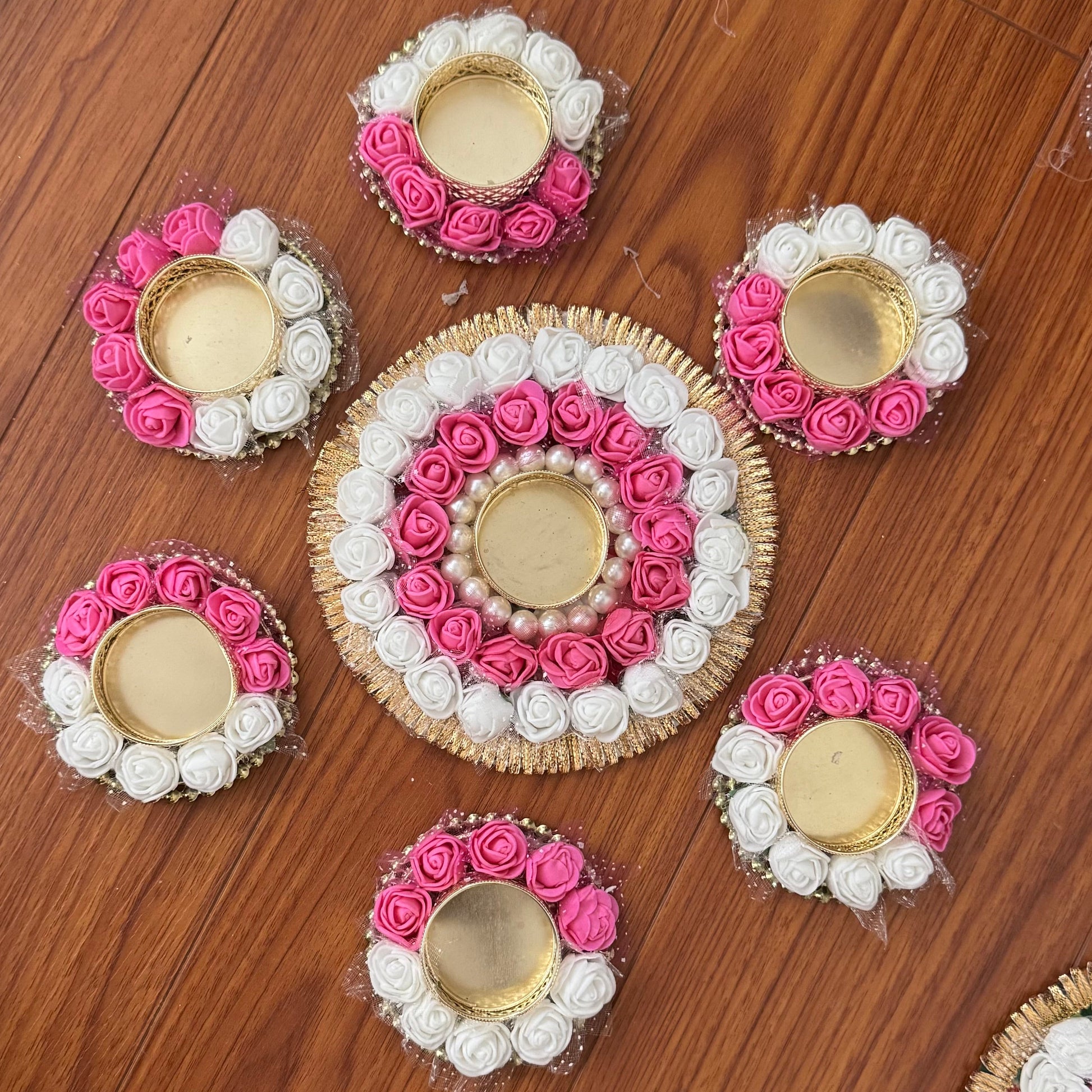 Decorative flower arrangements with tea light candles on a wooden floor